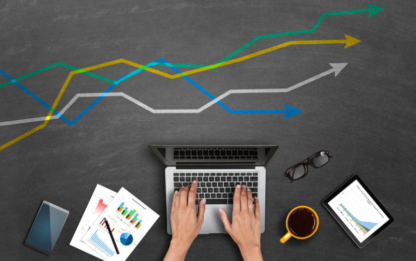 Hands typing on a laptop with charts and graphs, illustrating how to sell on Amazon with data-driven strategies.